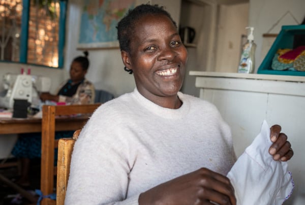 person smiling and holding fabric