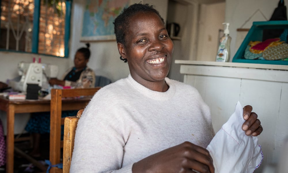 person smiling and holding fabric