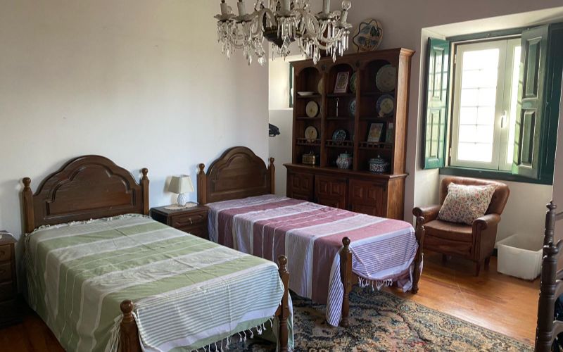 Large room with two beds and a chandelier.