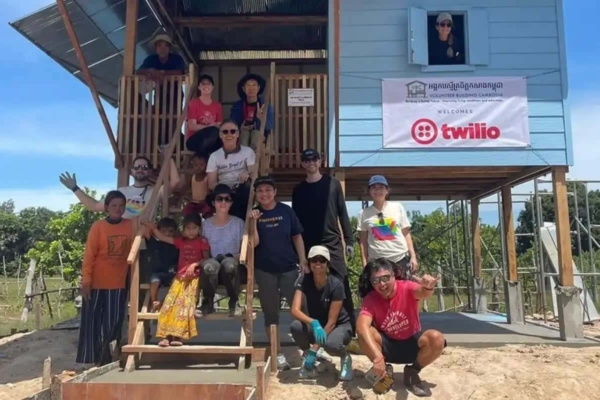 group of volunteers pose in front of a community building construction site