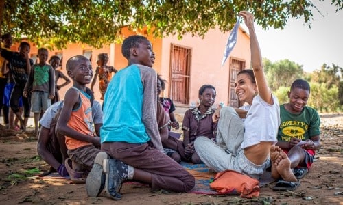 public health intern in Zambia giving an education presentation with kids