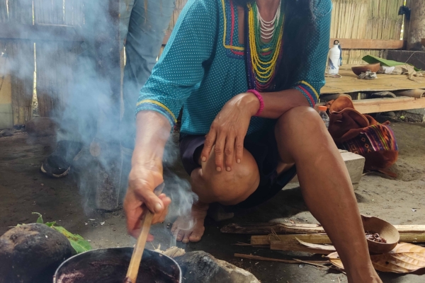 Local woman cooking cocoa seeds