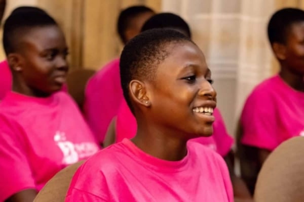 Smiling participants in pink B-GILD shirts enjoy an empowering leadership session designed to inspire young Black girls.