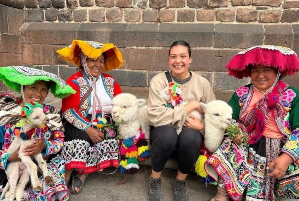 Intern with the locals of Machu Pichu and their llamas.