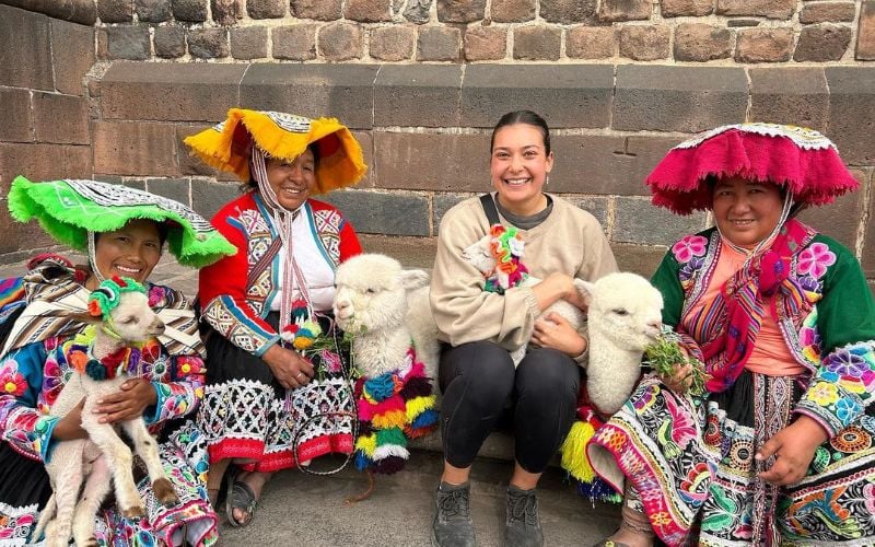 Intern with the locals of Machu Pichu and their llamas.