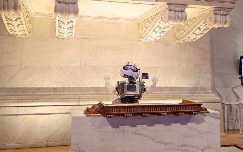 A robot from the robotics internship in Ecuador displayed on top of a podium.