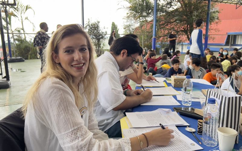 Intern smiling while grading the papers of the students