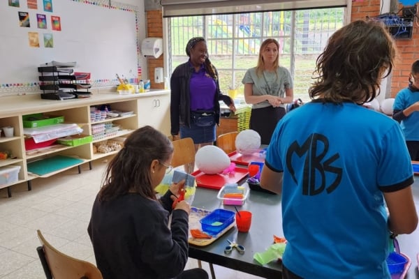 A group of interns helping the kids with their arts and crafts.