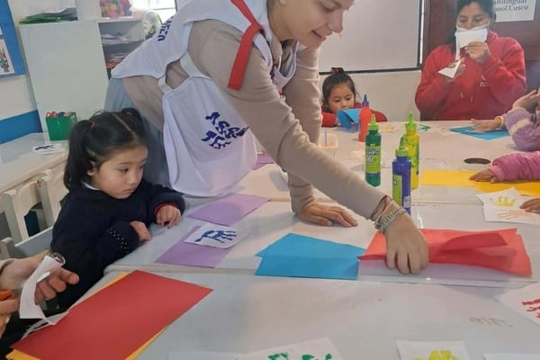 An intern helping out a child with arts and crafts.