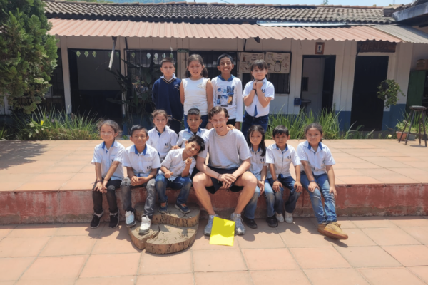 An intern posing for a picture with the students.