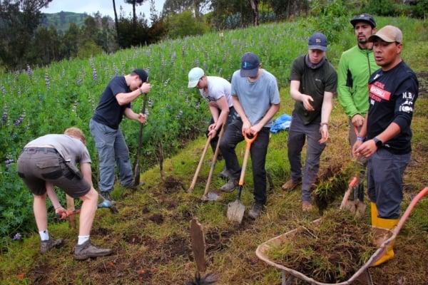 Interns work together to pass clay tiles for the restoration of a rural structure.