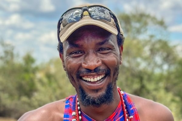 Local community member smiling outdoors, representing community-led sustainable tourism initiatives.